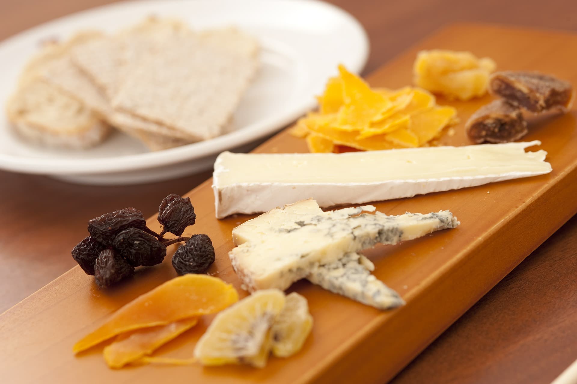 Holzplatte mit Käse und Trockenfrüchten