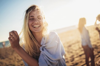 blonde Frau am Strand lächelt